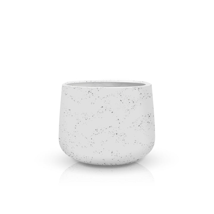 The Aura di Pietra Planter - Medium by Landmark Decor is a speckled ceramic planter with a rounded base on a reflective surface, offering a blend of luxury and nature, set against a plain white backdrop.