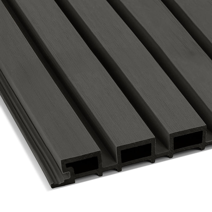 Close-up of Landmark Decors Dark Walnut Exterior WPC Panel showcasing dark gray composite cladding with grooved, textured surfaces, evenly spaced ridges, and hollow spaces, ideal for outdoor wall decoration or siding.
