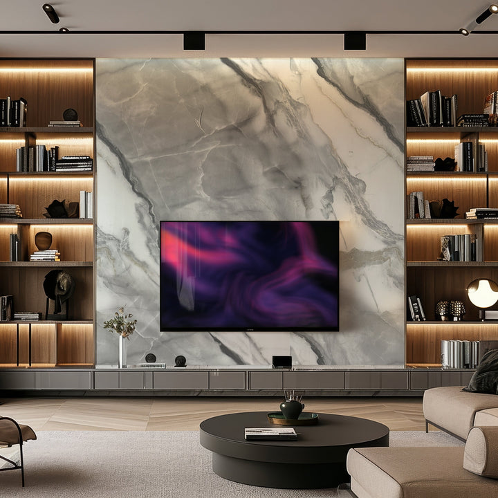 A modern living room features a Landmark Decor Obsidian Vein Marble Durable PVC Wall as a large accent, with a mounted flat-screen TV showing abstract art. Built-in lighted shelves display books and decor, while a round coffee table and gray sectional sofa complete this luxury interior design.