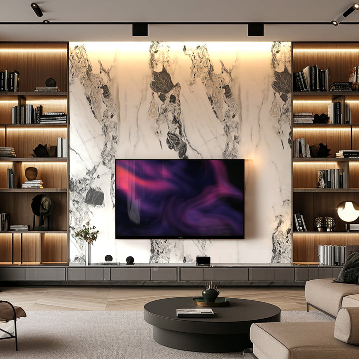 Featuring luxurious aesthetics, this modern living room boasts a wall-mounted TV against Landmark Decors Crystal Cliff Marble Durable PVC Wall panels, complemented by built-in lit wooden shelves and a round coffee table.