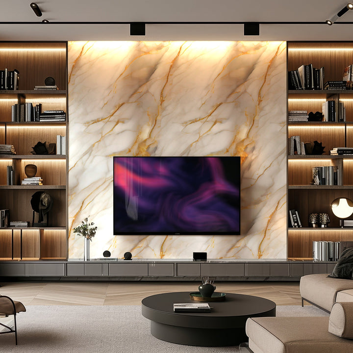 A modern living room boasts luxurious aesthetics with Landmark Decors Golden Sandstone Marble Durable PVC Wall panels, framing a mounted TV. Built-in shelves display books and decor while a circular coffee table sits beneath warm lighting accents that enhance the stylish interior design.