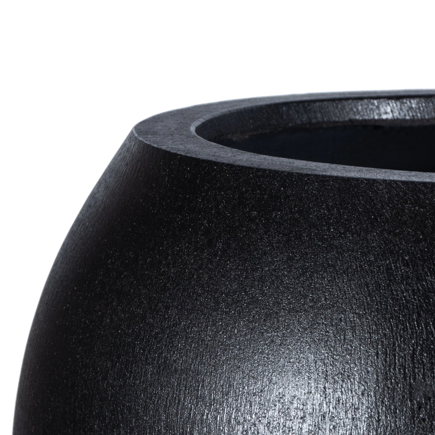 Close-up of the handmade Urban Vessel Planter by Landmark Decor: this black, rounded ceramic pot features a smooth, glossy surface with a visible thick edge and hollow interior. The lighting captures its matte finish, merging luxury with nature.